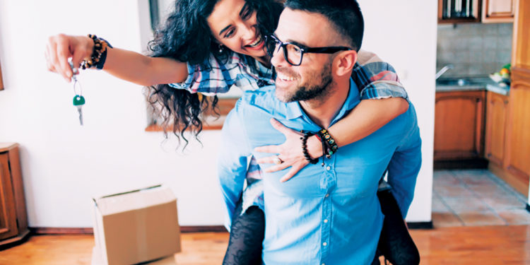 Young couple holding the keys for their new home.
